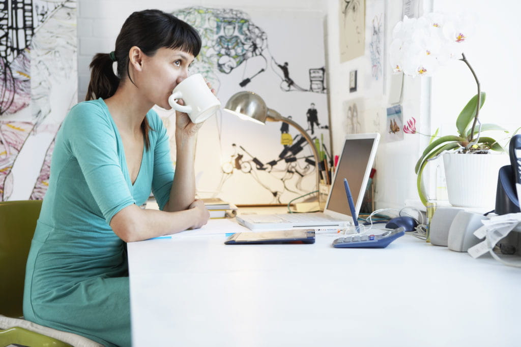 lady sipping coffee and working from home